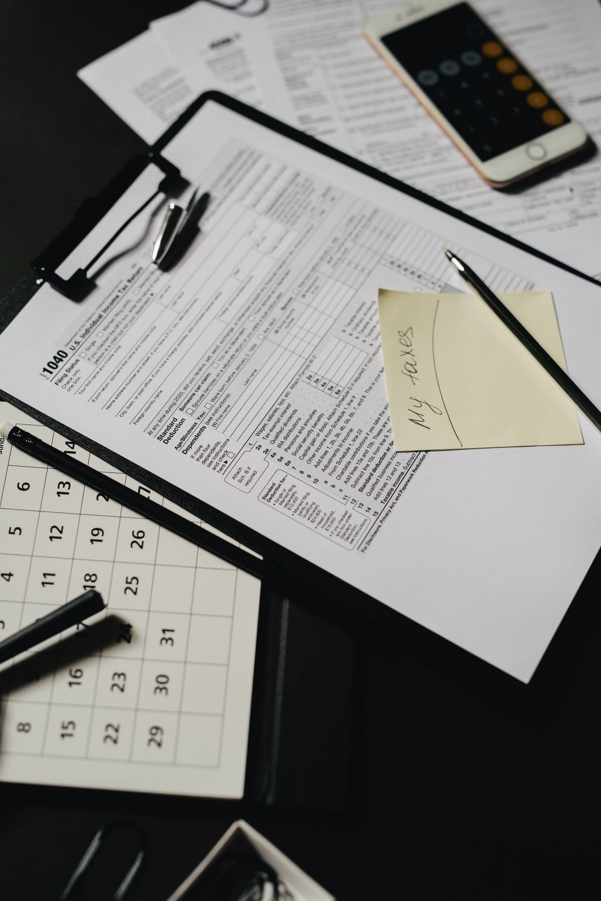 A close-up of a tax return form on a clipboard with a pen and desk.