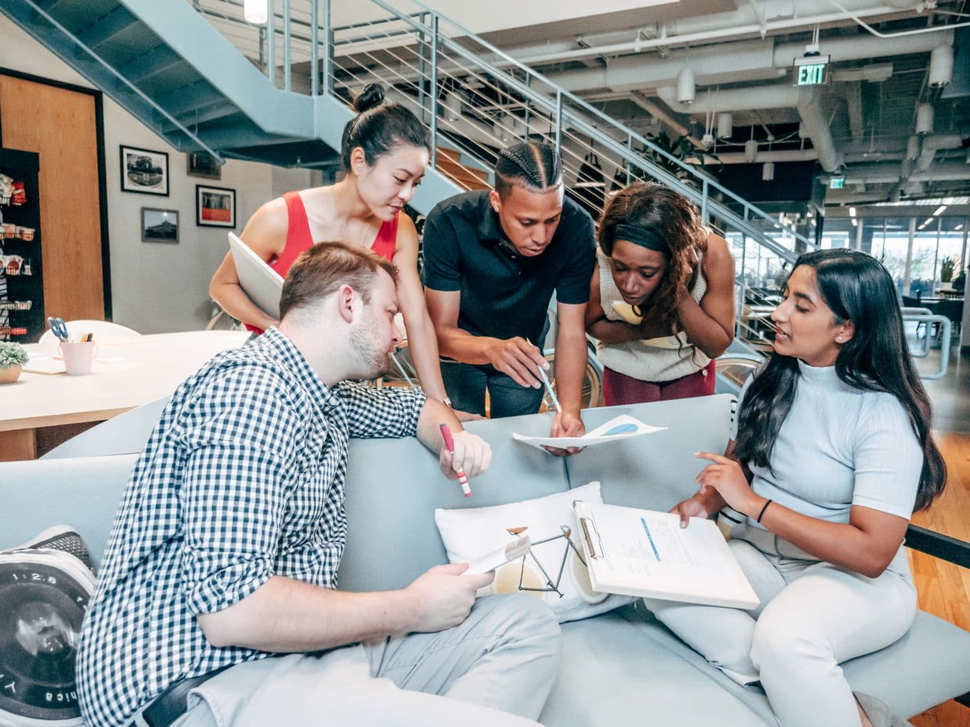 Colleagues collaborating around a table in a bright modern office.