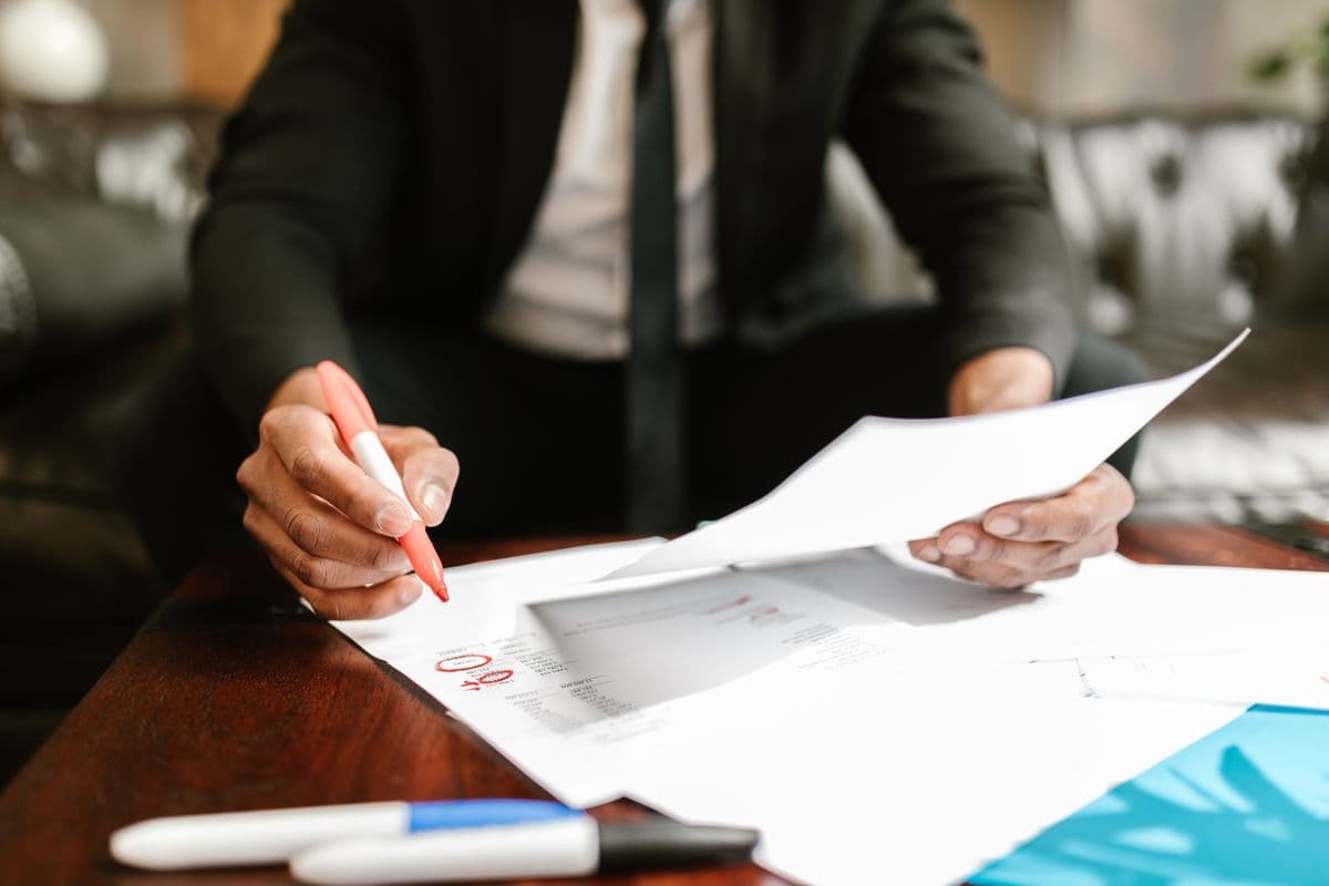 A professional reviewing financial documents at an office desk.
